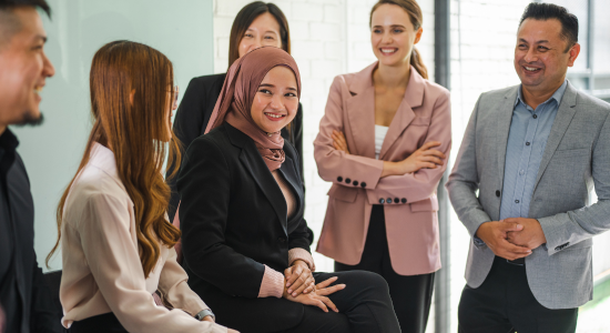 A diverse group of business professionals engaged in a casual discussion during a meeting.